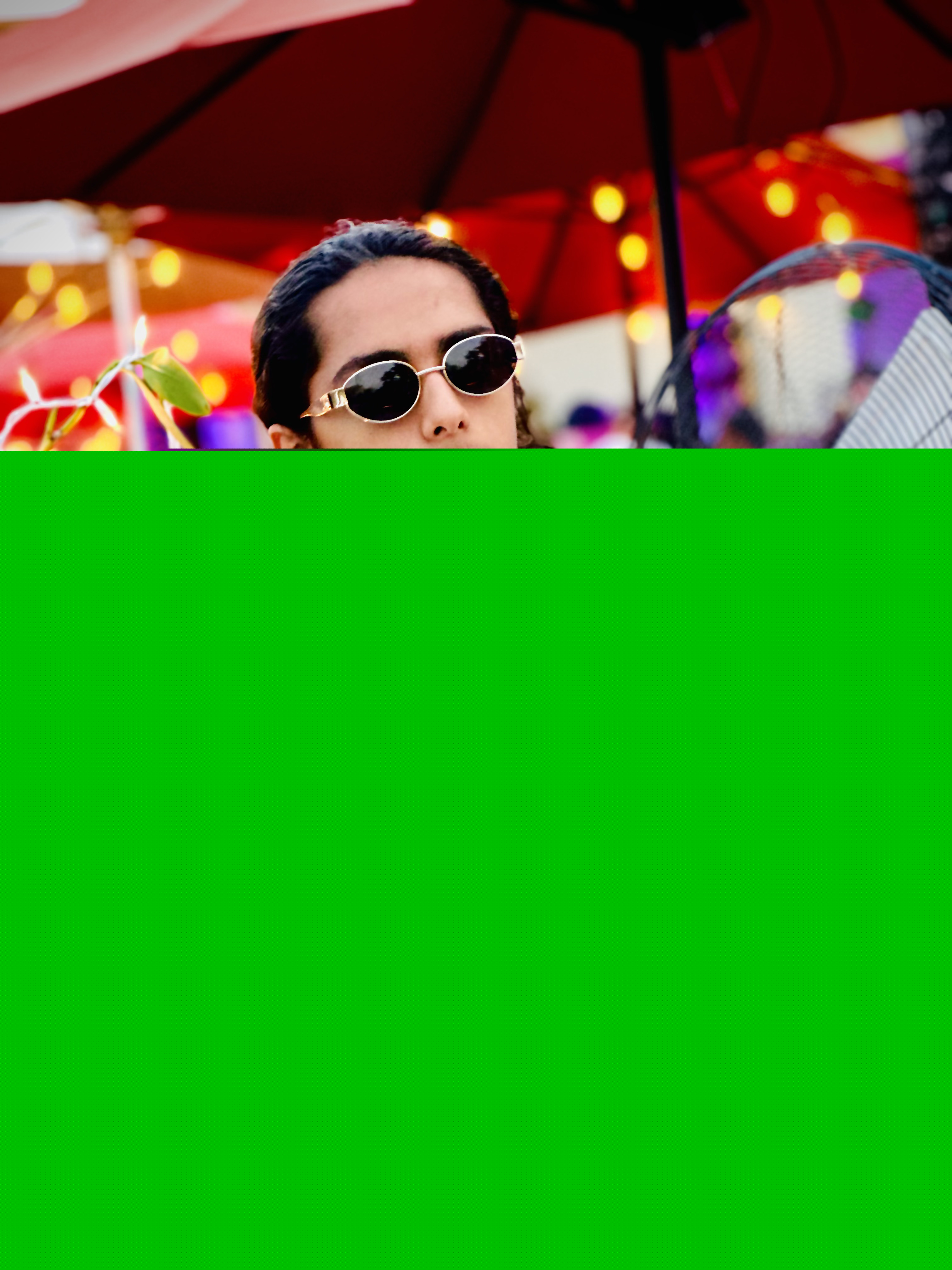 Aryan Rohira posing in front of a charming floral café setting